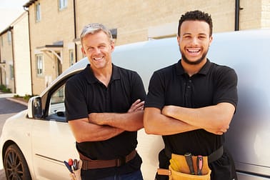 picture of happy plumbers by their fleet vehicle